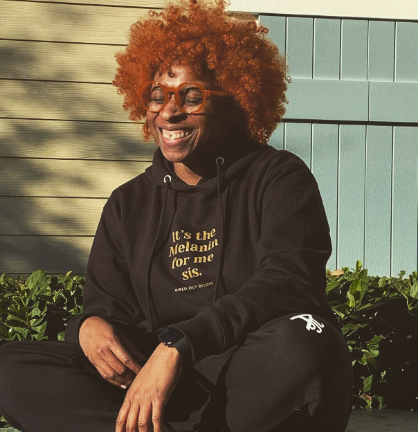 A person with curly hair sitting on a bench

Description automatically generated with low confidence